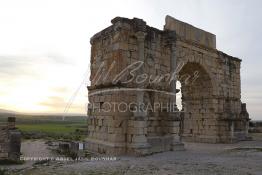 Image du Maroc Professionnelle de  L'arc de triomphe d'où prend son départ la voie principale (decumanus maximus) jusqu'à la porte de Tanger de l'ancienne ville romaine de Volubilis l'un des sites les mieux préservés au Maroc et le plus visité. La cité romaine se situe à proximité de Moulay Idriss Zerhoun à une trentaine de km au nord-ouest de Meknès, photo prise le jeudi 8 Mars 2012. Volubilis ville antique berbère Walili (Lauriers rose) qui date du 3e siècle avant J.-C. capitale du royaume de Maurétanie fondé comme seconde capital sous le règne de Juba II. (Photo / Abdeljalil Bounhar)
 